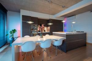 a kitchen with a large white island with stools at London 993 Loft 402 in Antwerp