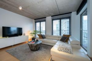 a living room with a couch and a tv at London 993 Loft 402 in Antwerp