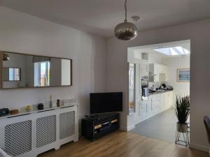 a living room with a tv and a mirror at Stones Throw-near harbour & beach Pet Friendly in Weymouth