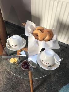 a glass table with a bowl of donuts and a tea kettle at House On The Hill in Richmond