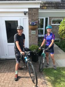 duas pessoas de pé com as suas bicicletas em frente a uma casa em House On The Hill em Richmond