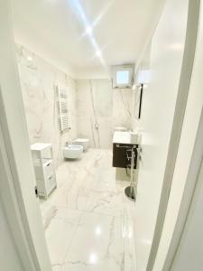 a white bathroom with a sink and a toilet at IL VIAGGIATORE RELAIS SUL MARE in Gaeta