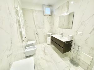 Baño blanco con lavabo y espejo en IL VIAGGIATORE RELAIS SUL MARE, en Gaeta
