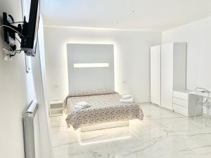 a white room with a bed and a mirror at IL VIAGGIATORE RELAIS SUL MARE in Gaeta