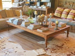 a living room with a coffee table with books at De Cango Farm in Oudtshoorn