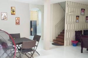 a dining room with a table and chairs and a staircase at J & I Homestay in Sibu