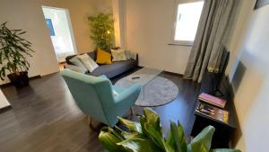 ein Wohnzimmer mit einem Sofa und einem Stuhl in der Unterkunft Apartamento T2 com Terraço grande in Quarteira
