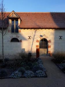 un edificio blanco con techo marrón en Le Bois des Chambres en Chaumont-sur-Loire