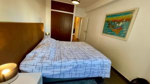 ein Schlafzimmer mit einem Bett und einem Wandgemälde in der Unterkunft Apartamento T2 com Terraço grande in Quarteira