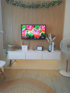 a television sitting on top of a white cabinet at Amaia Steps Nuvali fully furnished unit with swimming pool view near Carmelray Pitland in Calamba