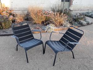 dwa krzesła siedzące obok siebie na ziemi w obiekcie Le Bois des Chambres w mieście Chaumont-sur-Loire