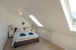 a bedroom with a bed with blue towels on it at Gone to the Beach - Sea Views Direct Beach Access in Saundersfoot