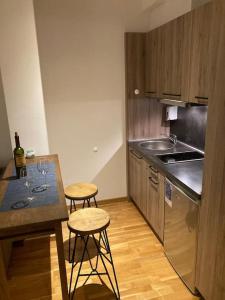 a kitchen with a table and two bar stools at Apartman Jelka Brzece in Brzeće