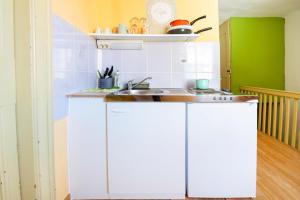 una cocina con armarios blancos y fregadero en Hostel Martin, en Koper