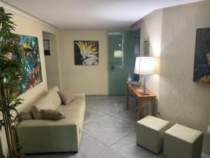 a living room with a couch and a table at Boa Viagem - Charmoso apartamento para casais in Recife