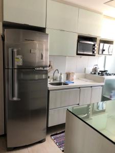 cocina con nevera de acero inoxidable y fregadero en Boa Viagem - Charmoso apartamento para casais, en Recife