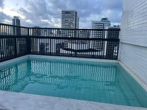 a swimming pool with a view of the city at Boa Viagem - Charmoso apartamento para casais in Recife