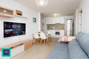 sala de estar con sofá gris y cocina en Sinda Apartment El Puertillo, en Arucas