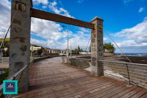 Sinda Apartment El Puertillo في أروكاس: جسر فوق الشاطئ مع السماء الزرقاء