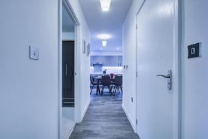 a hallway leading to a dining room with a table at 2 bed 2 bath Modern Apartment in East Acton in London