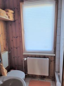 a bathroom with a toilet and a window with a radiator at Ferienwohnung 3 - a76814 in Groß Vollstedt