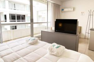 1 dormitorio con 1 cama y TV de pantalla plana en BALC0511 Cómodo Monoambiente por San Telmo en Buenos Aires