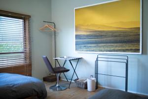 a bedroom with a bed and a desk and a painting at AMIGO HOUSE in Zushi +29 photos