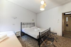 a white bedroom with two beds and a window at San Stae Apartment WIFI AC in Venice