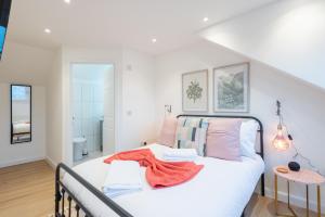 a bedroom with a bed with white sheets and pink pillows at The Pinkish House - 4 bed home in the town centre in Blairgowrie