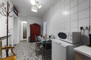 uma cozinha branca com uma mesa e um micro-ondas em San Stae Apartment WIFI AC em Veneza