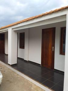 un edificio bianco con due porte e pavimento piastrellato di Bed&Breakfast VANILLA a Antsirabe
