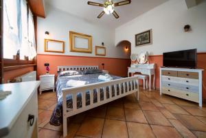 sypialnia z łóżkiem, komodą i telewizorem w obiekcie Le Palme w mieście Ospedaletti
