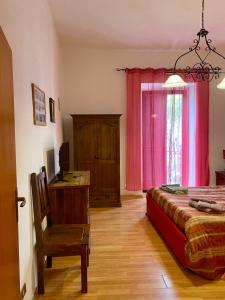 um quarto com uma cama, uma cadeira e uma janela em Holiday House Ginevra em Formia