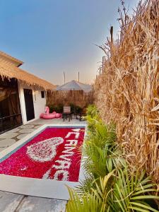 a garden with a red rug in front of a house at GLASS HOUSE with private pool in Lonavla in Lonavala