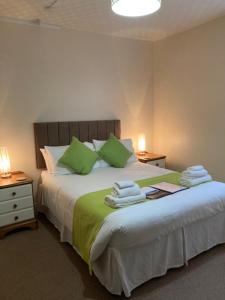 a bedroom with a large bed with green pillows at The Mayfair in Weymouth