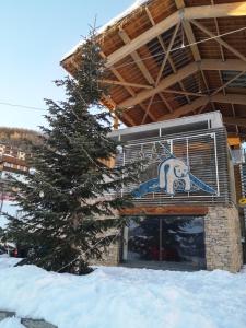 a building with a sign on it in the snow at LOGEMENT 4 PERSONNES in Orcières