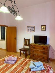 Holiday House Ginevra في فورميا: غرفة معيشة مع تلفزيون وخزانة خشبية