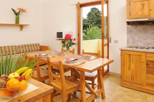 a kitchen with a wooden table with a bowl of fruit on it at Residence Oasis in Alghero