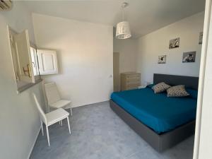 1 dormitorio con 1 cama azul y 1 silla en RockSea Apartments Attic Floor en Cefalú