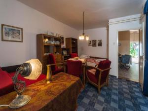 uma sala de estar com uma mesa e cadeiras vermelhas em Cocic Garden em Osijek