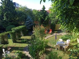 un jardín con mesa y sillas en el patio en Cocic Garden, en Osijek