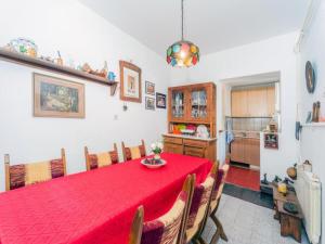 a dining room with a red table and a kitchen at Cocic Garden in Osijek