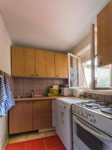 uma cozinha com armários de madeira e um forno de fogão branco em Cocic Garden em Osijek