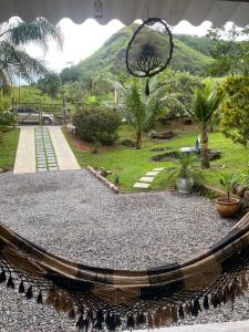 une balançoire dans un jardin avec une montagne en arrière-plan dans l'établissement Vale da Paz, à Guapimirim