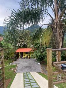 a house with a fence and a gravel driveway at Vale da Paz in Guapimirim