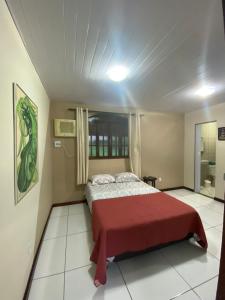 - une chambre avec un lit et une couverture rouge dans l'établissement Vale da Paz, à Guapimirim
