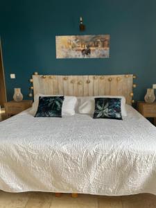 um quarto com uma cama branca e paredes azuis em Maison d'hôtes Bastide St Victor à 2,5 kilomètres de Lourmarin em Puyvert