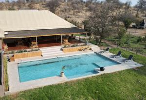 uma vista superior de uma piscina em frente a uma casa em Xhabe Safari Lodge Chobe em Chobe