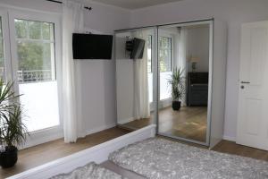 a living room with a mirror and a tv at Ferienwohnung Am Schippstroth in Wiefelstede