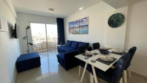 a living room with a blue couch and a table at OceanBlue Apartment in Protaras